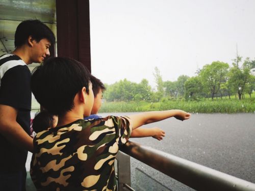 　　小朋友用手接雨。(资料图)　摄影　王亭川