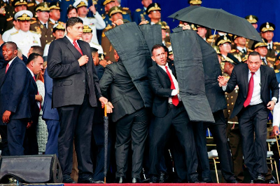 图：8月4日，在委内瑞拉首都加拉加斯，安全人员保护总统马杜罗。新华社 发