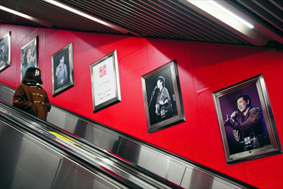 图为12月3日，在北京地铁4号线宣武门站，一名乘客观看音乐主题影像展展出的海报。新华社记者 鞠焕宗摄